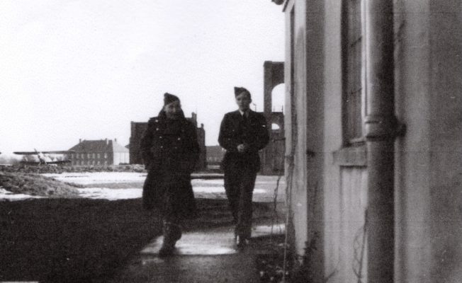 The stop butts can be seen in silhouette behind the man on the left in the greatcoat. To the right of the photo are the Belfast Truss Hangars and to the left is the Officers' Mess. On the far left is one of 615 Squadron's Hawker Hectors, which they flew from December 1937 until November 1938.  | Gerry Burke