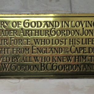 The brass plaque which accompanies the stained glass window at St. John The Evangelist, Newtimber. 
